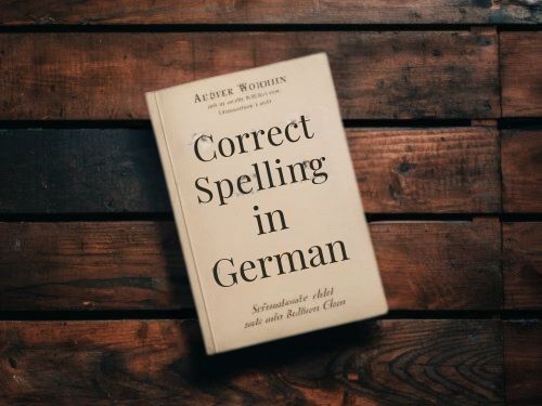 Ein Buch mit dem Titel „Correct spelling in German'' auf einem Holztisch skrivanek