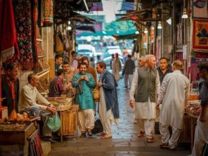 Eine belebte Marktszene mit Menschen in traditioneller Kleidung beim Einkaufen welche Sprache spricht man in Pakistan skrivanek