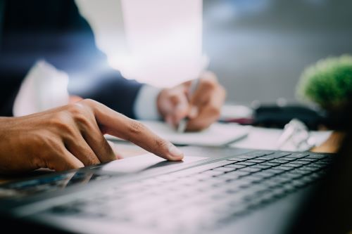 The businessman working at the table checks the text post editing skrivanek