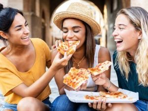 Drei junge Frauen essen draußen Pizza entspannt und gesellig danke auf italienisch ubersetzungsburo berlin