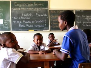 afrikanische Kinder sitzen in einem Klassenzimmer vor Tafeln mit englischen und franzosischen Wortern afrikanische Sprachen ubersetzungsburo berlin