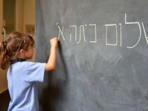 Madchen schreibt hebraische Schriftzeichen an eine Tafel hebraisches alphabet ubersetzungsburo berlin