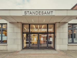 Eingang eines deutschen Standesamts mit automatischen Glasturen und der Aufschrift STANDESAMT ubersetzungsburo Berlin