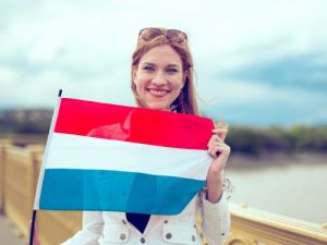 Frau mit niederländischer Flagge auf einer Brücke holländer oder niederländer Übersetzungsbüro Berlin