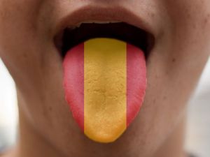Zunge mit aufgemaltem Spanien Flaggenmotiv als Symbol fur Sprache und Kultur Auswandern nach Spanien, Ubersetzungsburo Berlin