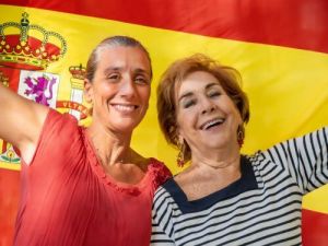 Zwei Frauen vor der spanischen Flagge Auswandern nach Spanien Ubersetzungsburo Berlin