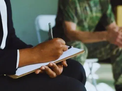 Ubersetzer schreibt auf Klemmbrett, daneben jemand in Militaruniform Ubersetzugnsburo Berlin