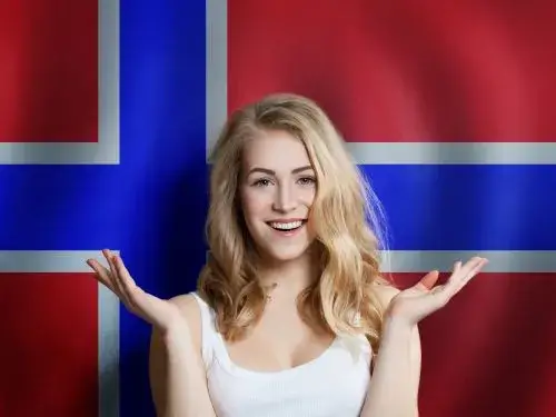 Frohliche junge Frau vor der norwegischen Flagge Auswandern nach Norwegen Ubersetzungsburo Berlin