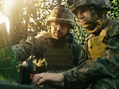 Zwei Soldaten analysieren Daten auf einem Laptop im Tarnnetz Fokus auf Kommunikation und Einsatzbereitschaft Ubersetzugnsburo Berlin