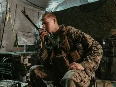 Soldat nutzt Funkgerät in einem mobilen Gefechtsstand zur sicheren Kommunikation im Blue-Force-Tracking-System
